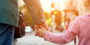 Parent and child holding hands.